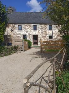 a stone barn with a fence in front of it at Gîte De Ty Louti in Plouyé