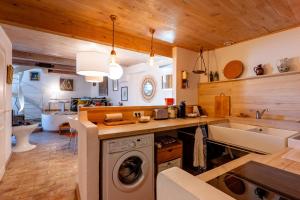 a kitchen with a washing machine and a sink at Cocooning in Puimoisson