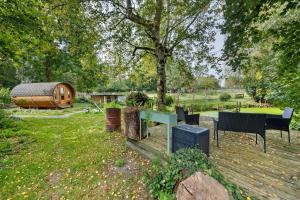 a backyard with a wooden deck with a house at das Fass de Olle Uhlhoff in Barlt +12 photos