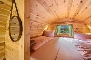 a room in a log cabin with two beds at das Fass de Olle Uhlhoff in Barlt