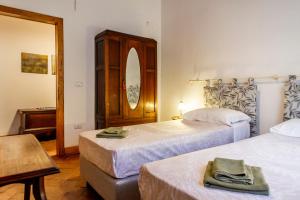 a bedroom with two beds and a table and a mirror at Residenza Palazzo Ghio in Scansano