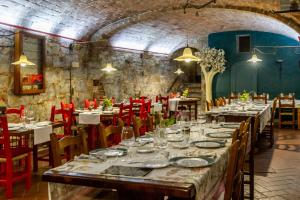 a dining room with tables and red chairs at Residenza Palazzo Ghio in Scansano