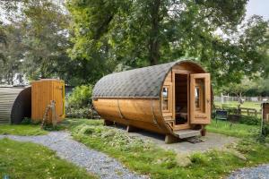 a small wooden cabin with a tin roof at das Fass de Olle Uhlhoff in Barlt