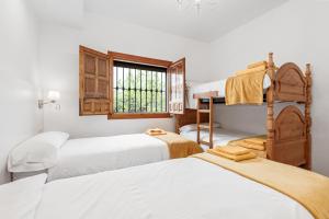 a bedroom with three beds and a window at Finca Llano de Fe in Málaga