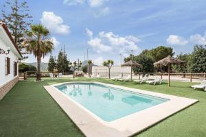a swimming pool in the middle of a yard at Finca Llano de Fe in Málaga