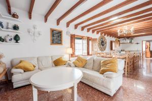 a living room with a white couch and a table at Finca Llano de Fe in Málaga