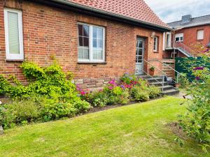 a brick house with a yard with flowers at Heiderast Wipperau in Oetzen