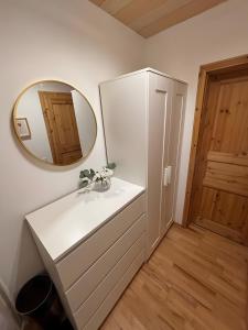 a bathroom with a mirror and a white dresser at Heiderast Wipperau in Oetzen +32 photos