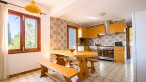 a kitchen with a wooden table and a wooden bench at Na Penyal Ref 246 in Cala Millor