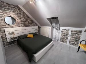 a bedroom with a black bed and a mirror at Pause Tranquille - Chambres d'hôtes in Sablé-sur-Sarthe