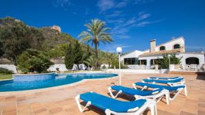 a villa with a swimming pool and lounge chairs at Na Penyal Ref 246 in Cala Millor