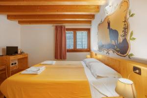a bedroom with a large yellow bed in a room at Agriturismo Soleil Levant Torgnon in Torgnon