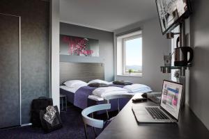 a hotel room with two beds and a laptop on a desk at Hotel Cabinn Vejle in Vejle
