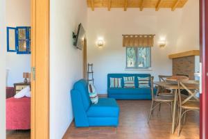 a living room with a blue chair and a table at Casa Da Ti Vanda in São Luis