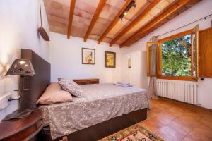 a bedroom with a bed and a table and a window at Tramuntana in Valldemossa +19 photos
