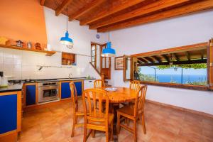 a kitchen with a wooden table and chairs at Tramuntana in Valldemossa