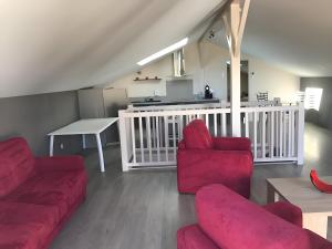 a living room with a red couch and a table at Loft Grand Confort Avec Piscine in Montalzat