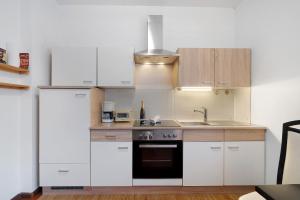 a kitchen with white cabinets and a sink and a stove at Katharina in Lana