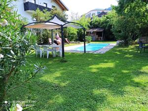 a woman sitting at a table under an umbrella in a yard at Katharina in Lana