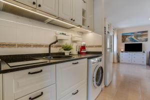 a kitchen with a sink and a washing machine at Oasis Duna _ Casa Martineli Pool in Corralejo