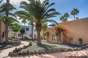 a courtyard with palm trees and a building at Oasis Duna _ Casa Martineli Pool in Corralejo