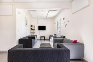 a living room with couches and a flat screen tv at Gîte De L'orchidée in Saint-Épain