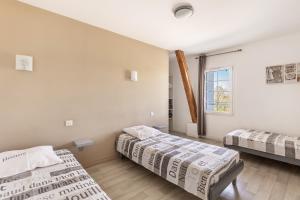 a bedroom with two beds and a window at Gîte De L'orchidée in Saint-Épain