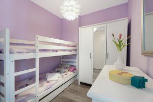 a childs bedroom with purple walls and bunk beds at Apto Jardin del Sol Beach-Pool in Puerto de Santiago +27 photos