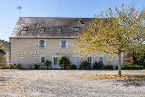 a large white house with a tree in front of it at Gîte De L'orchidée in Saint-Épain