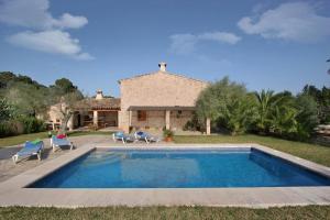 a villa with a swimming pool and a house at Butxaco in Pollença