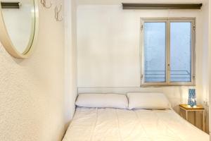 a small bed in a room with a window at 1a Linea mar port Llafranch in Llafranc