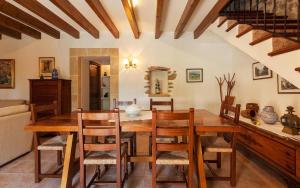 a dining room with a wooden table and chairs at Butxaco in Pollença