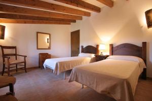 a hotel room with two beds and a chair at Butxaco in Pollença +16 photos