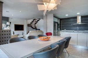 a kitchen with a large white table and chairs at Design villa with sea views in San Pol de Mar