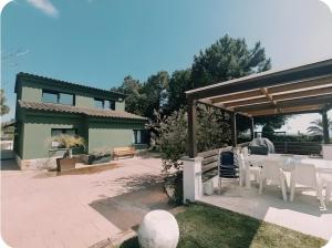 a patio with a table and chairs in front of a house at Design villa with sea views in San Pol de Mar