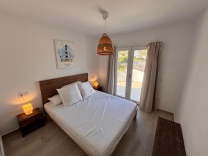 a bedroom with a bed with white sheets and a window at Casa Menorquina Son Moix in Ciutadella +36 photos