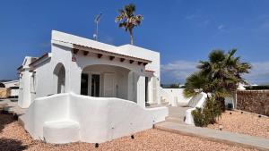 a white building with palm trees in front of it at Casa Menorquina Son Moix in Ciutadella