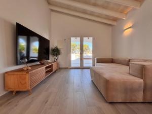 a living room with a couch and a flat screen tv at Casa Menorquina Son Moix in Ciutadella