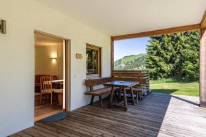 a room with a table and chairs on a deck at Sabina Dolomites Piz in Alpe di Siusi