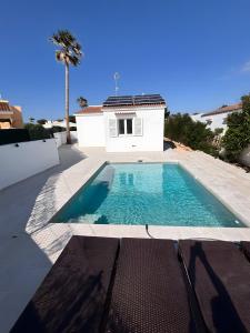 a swimming pool in front of a house at Casa Menorquina Son Moix in Ciutadella