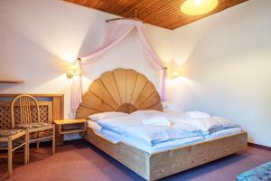 a bedroom with a large bed with a wooden headboard at Sabina Dolomites Piz in Alpe di Siusi +21 photos