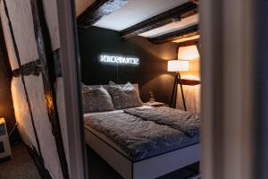a bed in a room with a sign on the wall at Lauterbach im Herzen der Altstadt in Lauterbach