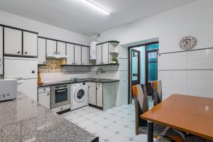 a kitchen with a washing machine and a table at Apto Casco viejo Castro Urdiales in Castro-Urdiales