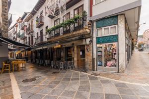 an empty street in a city with tables and chairs at Apto Casco viejo Castro Urdiales in Castro-Urdiales