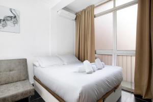 a bedroom with a bed and a chair and a window at Estudio centro de Torremolinos in Torremolinos