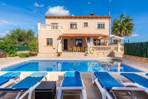 a villa with a swimming pool and a house at Los tres soles in Portocolom
