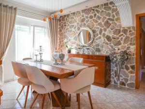 a dining room with a table and chairs and a stone wall at Villa Elysian in Antimácheia