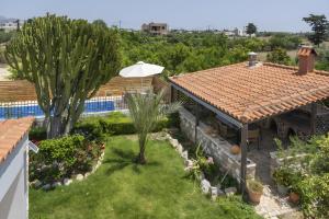 a backyard with a pool and a house with an umbrella at Villa Elysian in Antimácheia