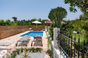 a backyard with a swimming pool and a fence at Villa Elysian in Antimácheia