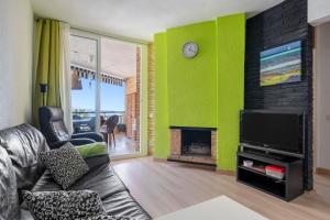 a living room with a couch and a fireplace at Tirreno 304 in La Pineda